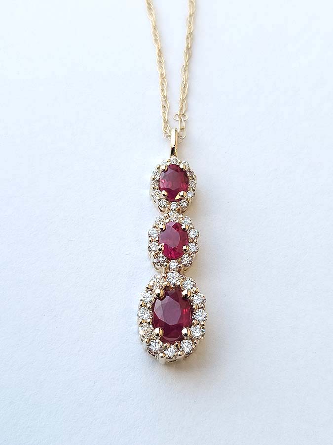 three-tier-ruby-halo-diamond-pendant-necklace Three tear ruby necklace